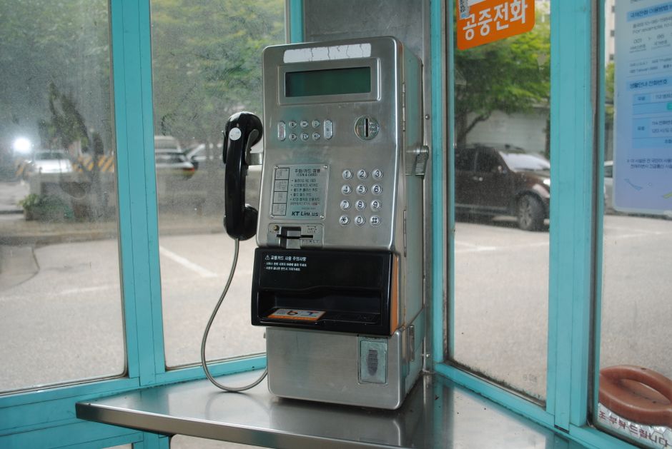 스마트폰으로 통신비 미환급금을 조회하고 환급받는 모습을 상징하는 이미지. 휴대폰 화면에 환급 알림이 뜨고 주변에 동전과 지폐가 흩어져 있다.