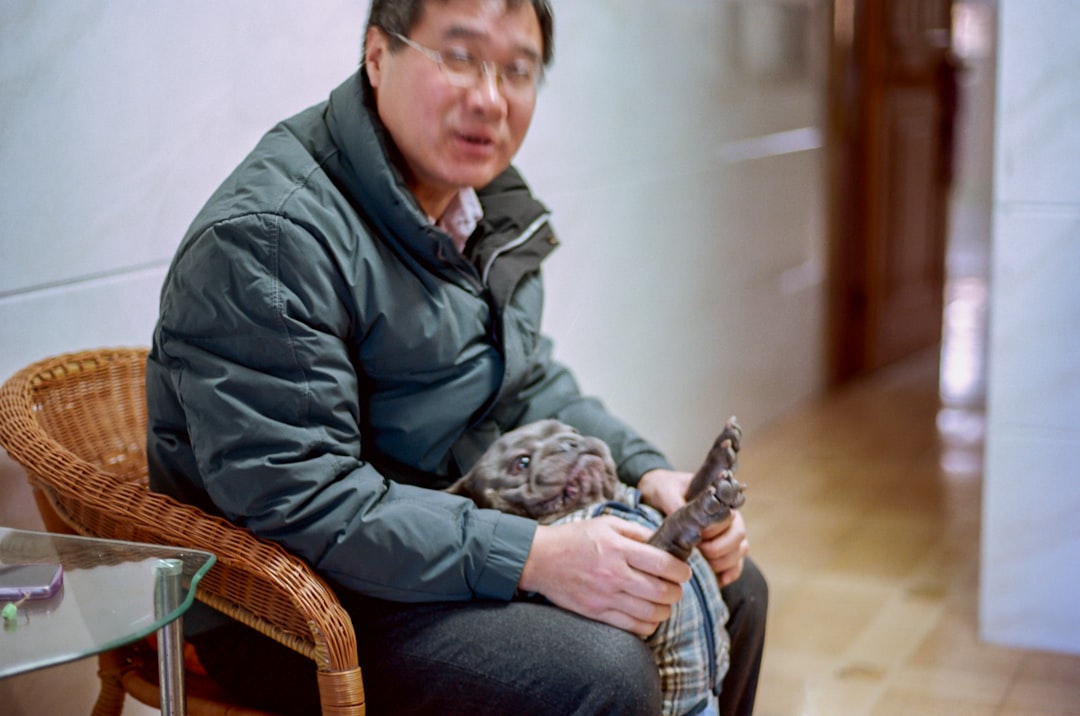 수의사가 반려동물을 진료하는 모습. 뒤편으로 의료 차트와 장비가 보이며, 높은 진료비의 중요성을 암시한다.